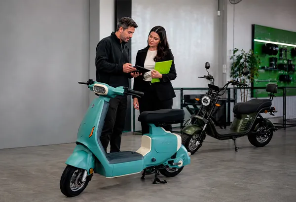 Cliente e consultor da e-Hub conferindo a ficha técnica de uma scooter elétrica no showroom